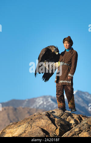 Chasseresse eagle kazakhs traditionnels sur une falaise avec son golden eagle qui est utilisé pour chasser pour fox et fourrure de lapin. Ulgii, l'ouest de la Mongolie. Banque D'Images