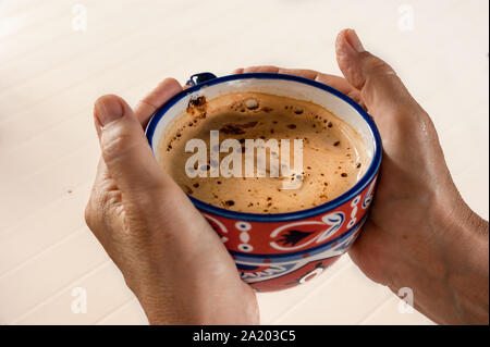 Les mains d'une vieille femme tenant la tasse de café Banque D'Images