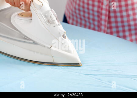 Close-up of a woman's hand stroking , sur la table à repasser Banque D'Images