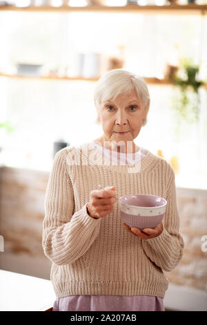 Femme en pull-over chaud de consommer de l'avoine le matin Banque D'Images