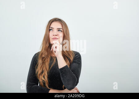 Fille aux cheveux brun en robe noire sur fond blanc isolé montre les émotions Banque D'Images