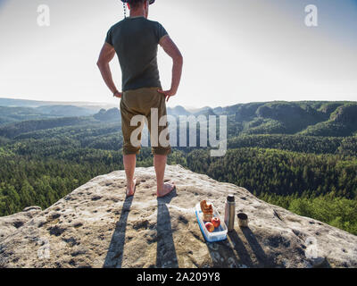 Séjour montagnard au repos sans chaussures sur point de vue. Brink metal touristiques fiole et repas santé. La randonnée dans les montagnes de la forêt Banque D'Images