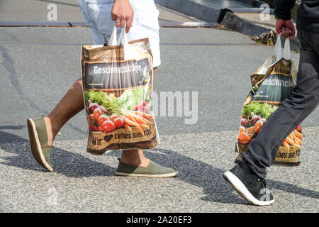 Les clients emportent leurs achats dans des sacs en plastique pleins du supermarché Allemagne Europe Banque D'Images