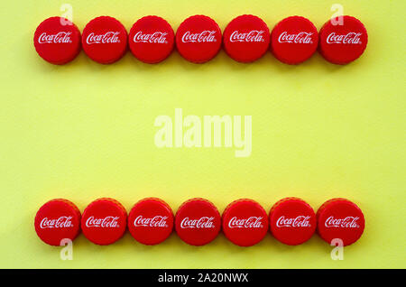 KHARKOV, UKRAINE - 8 septembre 2019 : de nombreux red caps avec coca cola logo sur fond jaune. Le Coca-Cola est une boisson sans alcool célèbre d Banque D'Images