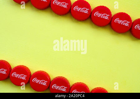KHARKOV, UKRAINE - 8 septembre 2019 : de nombreux red caps avec coca cola logo sur fond jaune. Le Coca-Cola est une boisson sans alcool célèbre d Banque D'Images