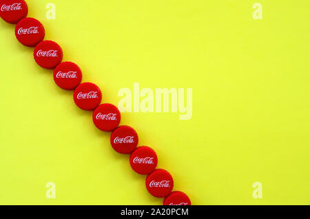 KHARKOV, UKRAINE - 8 septembre 2019 : de nombreux red caps avec coca cola logo sur fond jaune. Le Coca-Cola est une boisson sans alcool célèbre d Banque D'Images