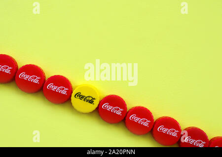 KHARKOV, UKRAINE - 8 septembre 2019 : de nombreux red caps avec coca cola logo sur fond jaune. Le Coca-Cola est une boisson sans alcool célèbre d Banque D'Images