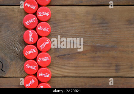 KHARKOV, UKRAINE - 8 septembre 2019 : de nombreux red caps avec coca cola logo sur fond de bois. Le Coca-Cola est une boisson sans alcool célèbre d Banque D'Images