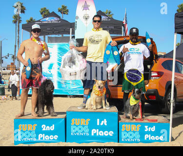 Huntington Beach, Californie, USA. 28 Septembre, 2019. Les gagnants de la Division en tandem - Homme et chien sur une planche de surf sont Brody, un Labranoodle avec Nate (2e place), Skyler, un propriétaire à talon, avec Homer Henard (1e place), et Maya, un Australien Bétail Chien, propriétaire avec Gilson de Moraes (3ème place) à la 11e édition de la compétition de Surf Surf City dog Chien tenu à Huntington Beach Huntington Beach, Californie le 28 septembre 2019. Banque D'Images