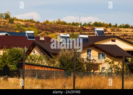 Chauffe-eau solaire sur le toit des maisons. Banque D'Images