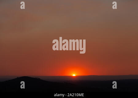 Smokey coucher de soleil sur la Cordillère australienne, les particules de fumée sont d'incendies bloquent la lumière provoquant un rouge profond ciel brumeux. Banque D'Images