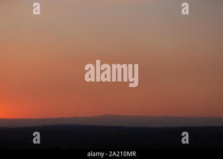 Smokey coucher de soleil sur la Cordillère australienne, les particules de fumée sont d'incendies bloquent la lumière provoquant un rouge profond ciel brumeux. Banque D'Images