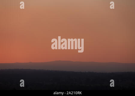 Smokey coucher de soleil sur la Cordillère australienne, les particules de fumée sont d'incendies bloquent la lumière provoquant un rouge profond ciel brumeux. Banque D'Images