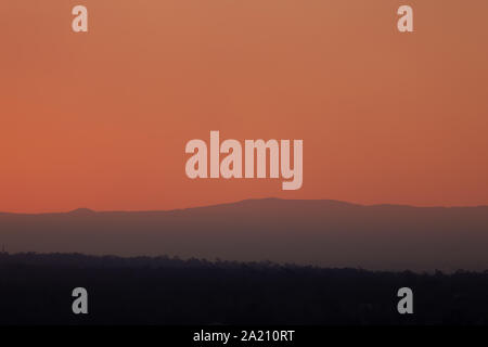 Smokey coucher de soleil sur la Cordillère australienne, les particules de fumée sont d'incendies bloquent la lumière provoquant un rouge profond ciel brumeux. Banque D'Images