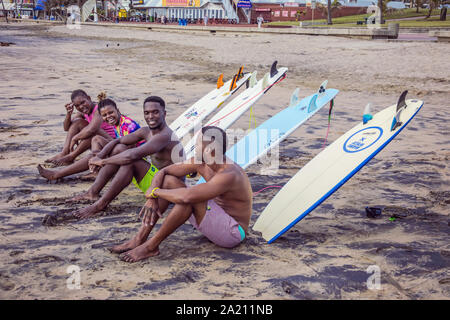 Des gens assis avec leurs planches de surf sur la plage de Durban Banque D'Images