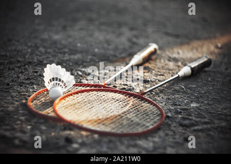 Image en noir et blanc de l'asphalte, qui a mis de volant et deux raquettes de badminton rouge vif. Banque D'Images