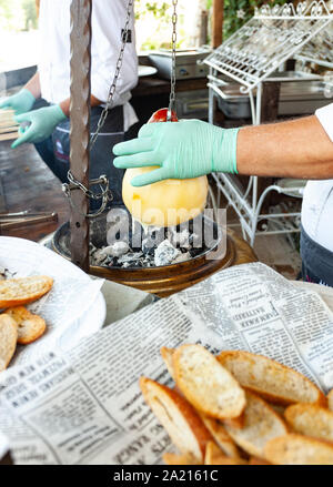 Typique de l'Italie du Sud, au four fromage fondu appelé sur le Caciocavallo charbons ardents. Banque D'Images