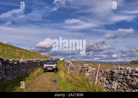 Voiture sur route non asphaltée au sud de Hawes. Yorkshire Dales National Park, England. Banque D'Images