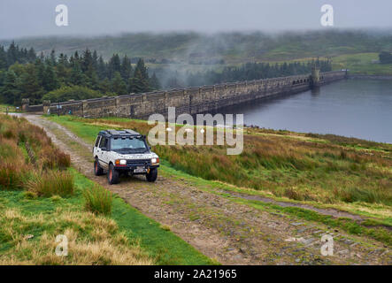 Voiture sur route non asphaltée par le SCAR Chambre barrage du réservoir. Yorkshire Dales National Park, England. Banque D'Images