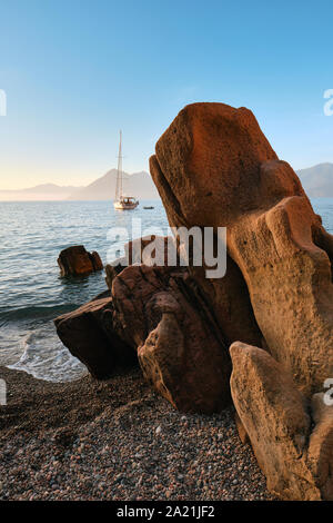 Un yacht, des formations de roche de granit rouge et la plage d'Plage de Ficaghjola / Plage de Ficajola et le golfe de Porto, Calanques de Piana Corse France. Banque D'Images