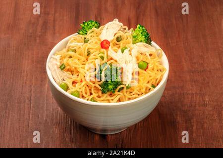 Nouilles Soba aux légumes et viande de poulet sur un fond rustique en bois foncé Banque D'Images