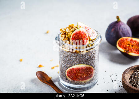 Chia pudding aux figues et granola dans un bocal. Petit-déjeuner végétalien sain concept. Banque D'Images