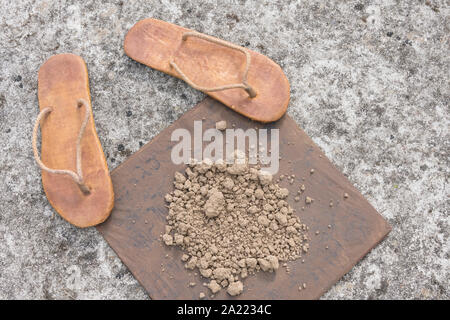 Flipflops hippy usés et carré avec la masse sur la surface du béton. La théorie de la terre plate métaphore, télévision earthers, théories du complot, preuve de la terre plate. Banque D'Images