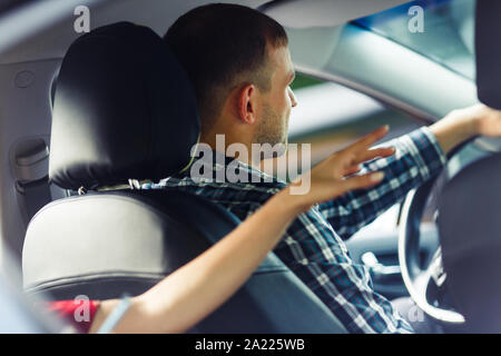 Photo de l'arrière du conducteur et passager volant derrière sa main vers l'avant Banque D'Images