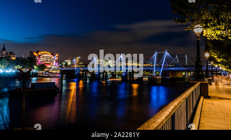 Nuit paysage urbain d'Hungerford Bridge & Charing Cross Station lights reflète dans la Tamise. Chemin de Southbank London Banque D'Images