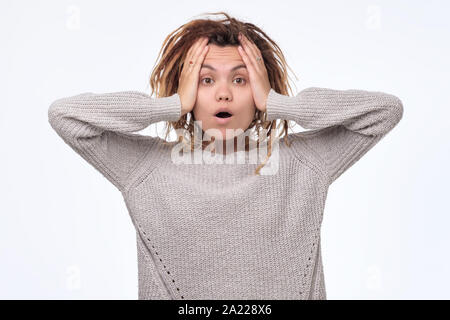 Jeune femme hurlant de terreur avec les mains sur sa tête, à la recherche dans panique à l'appareil photo. Du visage négatif l'émotion humaine. Banque D'Images