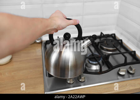 Man hand holding métalique électrique dans la cuisine. Électrique utilise l'eau chaude pour faire bouillir des boissons telles que le thé, café, lait en poudre, ou autres Banque D'Images