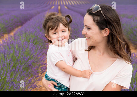 Happy mother and daughter parmi les champs de lavande en été Banque D'Images