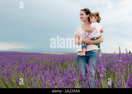Happy mother and daughter parmi les champs de lavande en été Banque D'Images