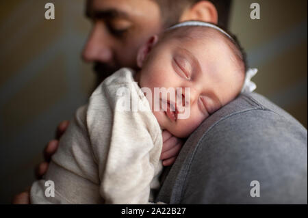 Close up of newborn baby's face dormir sur l'épaule du père à la maison Banque D'Images