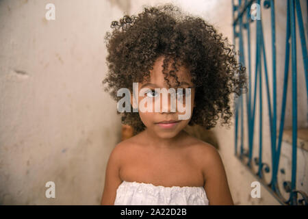 Belle jeune fille afro-brésilien avec des cheveux bouclés et robe blanche, de sourires Banque D'Images