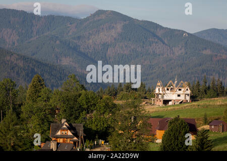 Un paysage de l'antenne de nouveaux logements qui est dominé par les montagnes de Tatra dans la ville polonaise de Koscielisko, le 16 septembre 2019, près de Zakopane, Pologne, Malopolska. La richesse locale encourage le tourisme de court séjour appartements et propriétés de Zakopane et de la région du Parc National des Tatras, une destination très populaire pour les activités de plein air des villes-pôles d'habitation mais au prix de l'environnement local et du paysage. Banque D'Images
