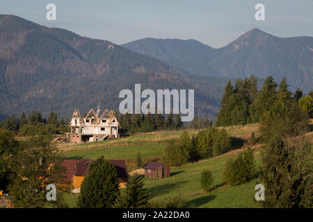 Un paysage de l'antenne de nouveaux logements qui est dominé par les montagnes de Tatra dans la ville polonaise de Koscielisko, le 16 septembre 2019, près de Zakopane, Pologne, Malopolska. La richesse locale encourage le tourisme de court séjour appartements et propriétés de Zakopane et de la région du Parc National des Tatras, une destination très populaire pour les activités de plein air des villes-pôles d'habitation mais au prix de l'environnement local et du paysage. Banque D'Images
