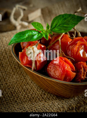 Avis de tomates cerises séchées sur la vieille table en bois Banque D'Images
