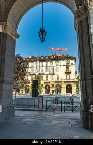 Un grand panneau publicitaire, haut au-dessus des bâtiments baroques le long de la via Sachhi vu à travers les arches de la gare de Porta Nuova, Turin, Italie Banque D'Images