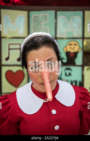 Membre du personnel du parc de Pinocchio habillé de travail par un Pinocchio Banque D'Images