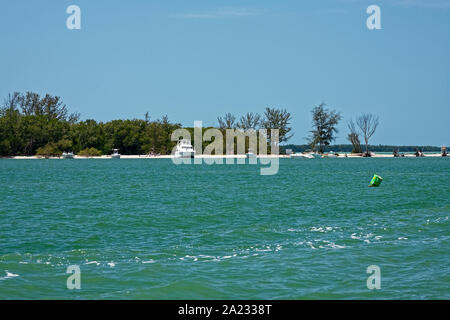 Motor bateaux ancrés, plage de sable, d'arbres, l'eau, les gens aqua détente, la bouée verte, l'île de Pine Island, son, Charlotte Harbor, Cayo Costa, FL, Perle Banque D'Images