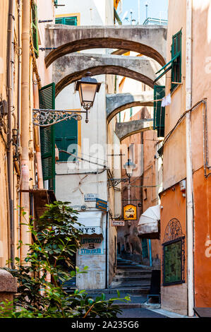 Sanremo, Italie - 01 septembre 2019 : vieille ville médiévale ancienne étroite rue pleine de lanternes, de construction arcs qui pendait entre les façades des bâtiments Banque D'Images