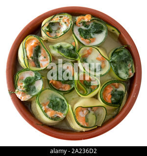 Plat de céramique ronde avec rouleaux de sushi cuit saumon - épinards et fromage mascarpone mélangé avec des rubans de courgettes roulées dans. Banque D'Images