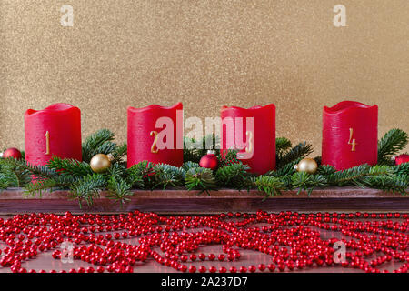 Bougies de l'avent rouge traditionnel avec des numéros et décoration de Noël, de la direction générale de la fir avec Garland, sur fond d'or Banque D'Images