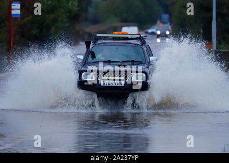 Un 4x4 Mitsubishi making a splash en conduisant à travers les inondations en Castleford Banque D'Images