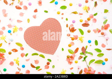 Boîte cadeau en forme de coeur télévision jeter Vue supérieure avec printemps coloré décoration florale Banque D'Images