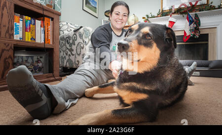 Les jeunes rescue dog jouer avec de nouveaux membres de la famille. Banque D'Images