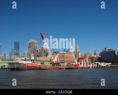 New Yok Harbour et jetées sur le rivage de Manhattan avec de grands navires et les grues de construction Banque D'Images