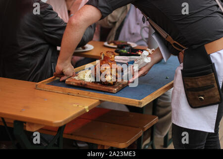 Festival d'octobre, Oktoberfest, repas Haxn. Jambon bavarois traditionnel, Schweinshaxe, servi sur une assiette en bois, Banque D'Images