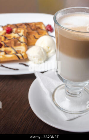 Des gaufres avec du café latte viennois, sur une table en bois. Banque D'Images